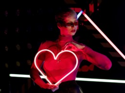 girl with heart shaped red neon light on neon light background