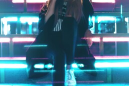 girl seated on stairs with neon light