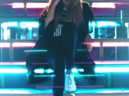 girl seated on stairs with neon light