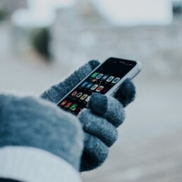 ragazza che usa un iphone in inverno con guanti
