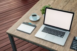 laptop, notepad and coffee on wooden table ready for working