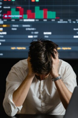 guy with glasses and beard desperate after checking crypto market on laptop